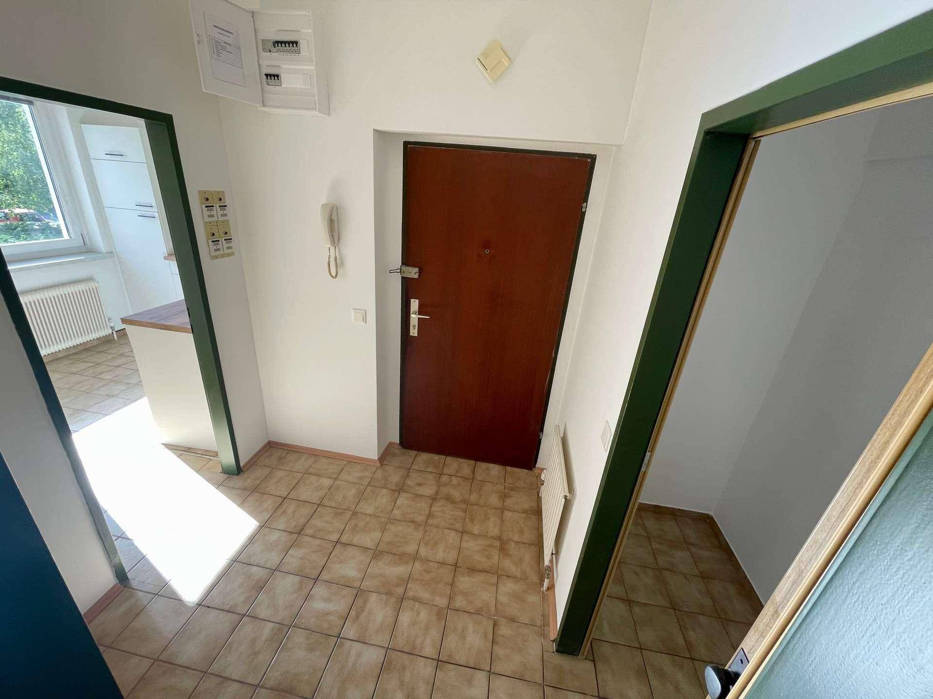 Eingangsbereich mit Fliesenboden und Zugang zu verschiedenen Räumen der Wohnung.