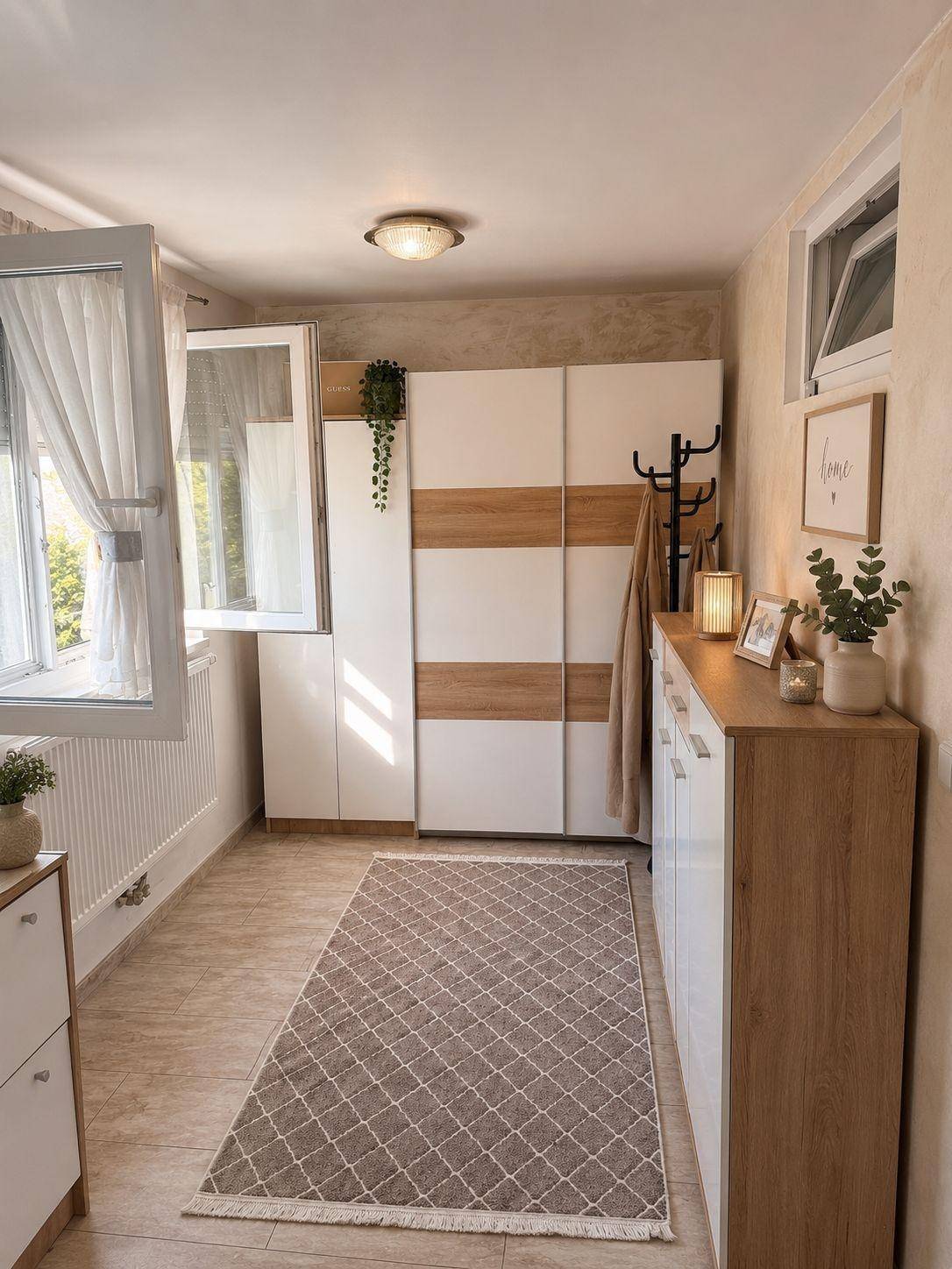 Heller Flur mit Garderobenschrank, Kommode und Fenster für natürliches Licht.