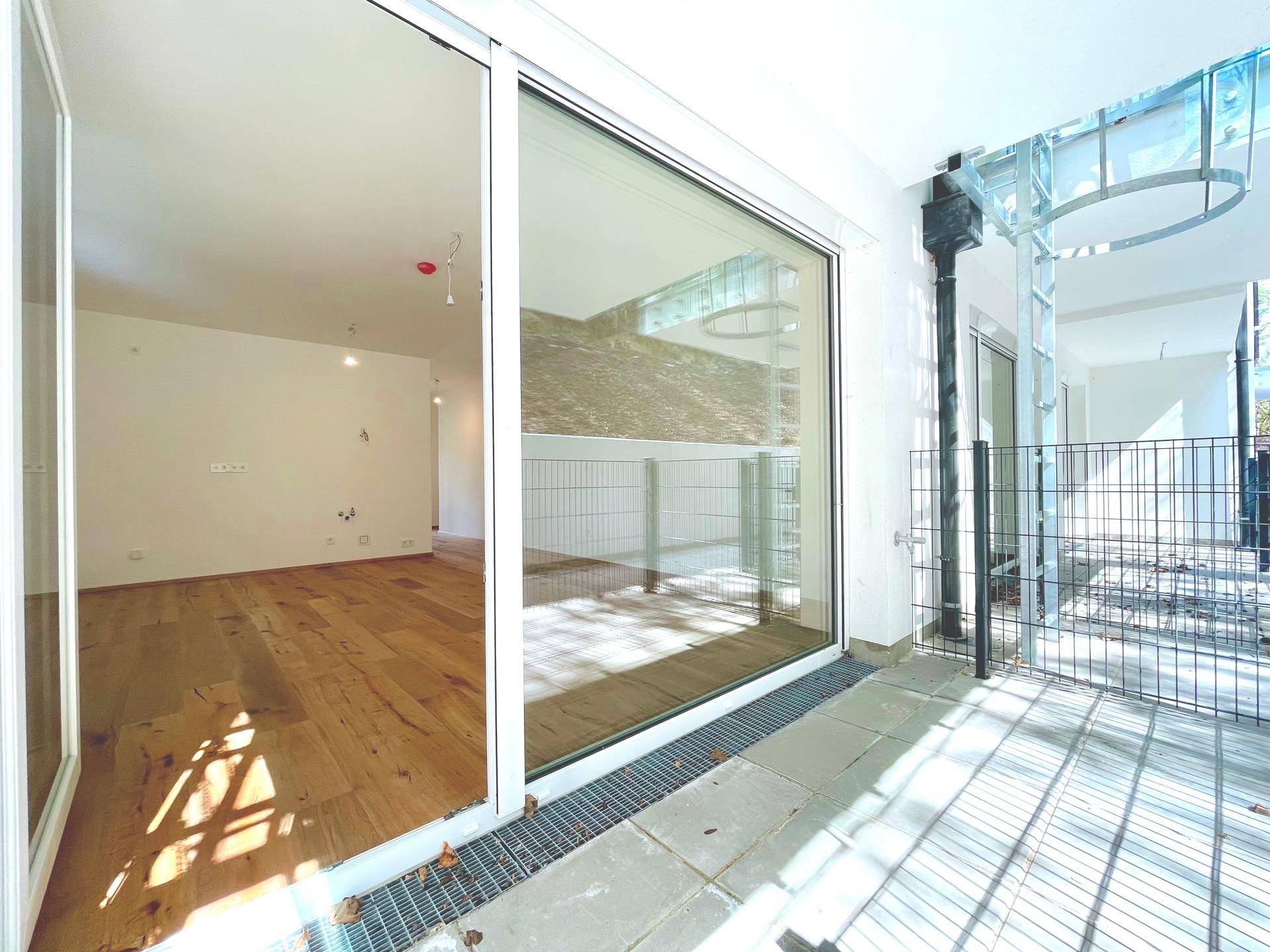 Private Terrasse mit Fliesenboden und direktem Zugang zum Innenbereich, umzäunt für mehr Privatsphäre.