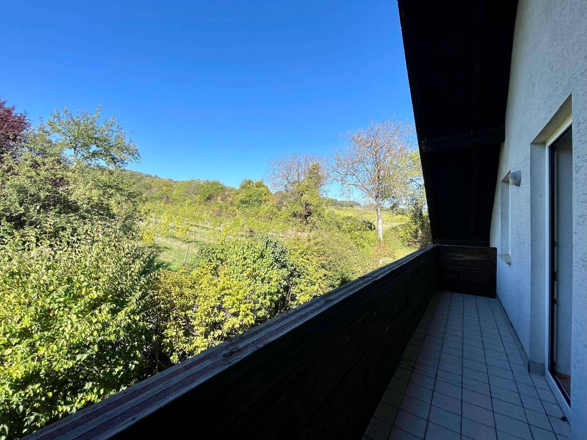 Balkon mit weitem Blick über die grüne Landschaft und Weinberge.