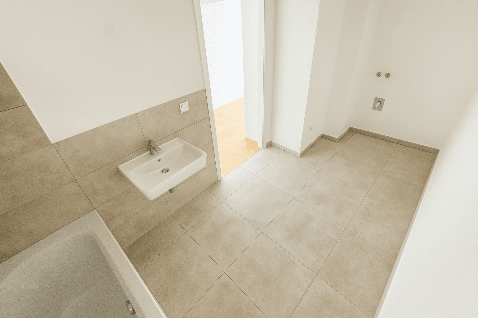 Heller, leerer Wohnraum mit Holzboden und großen Fenstern, die viel Tageslicht hereinlassen.