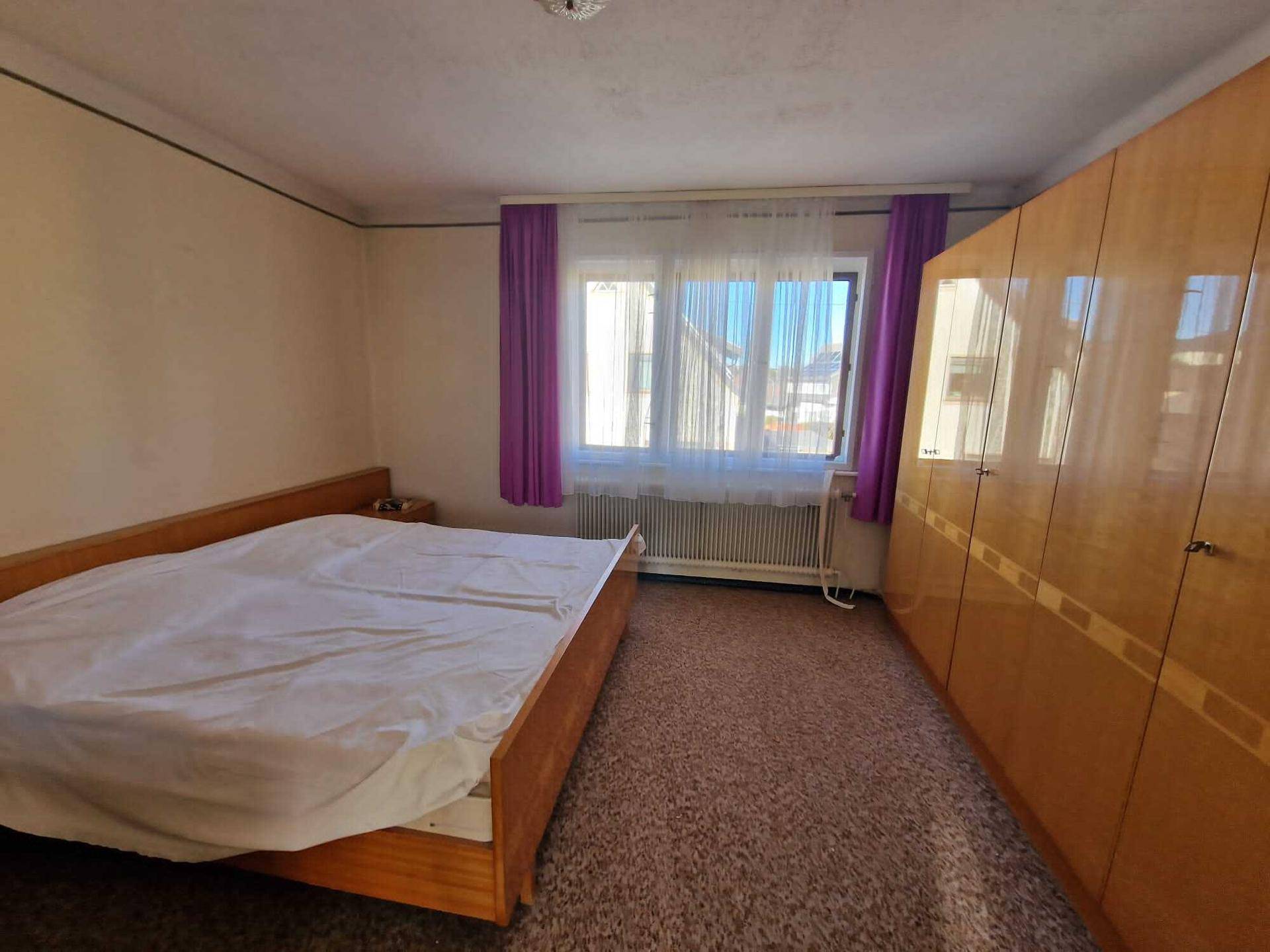 Gemütliches Schlafzimmer mit Teppichboden, Doppelbett und großem Kleiderschrank.