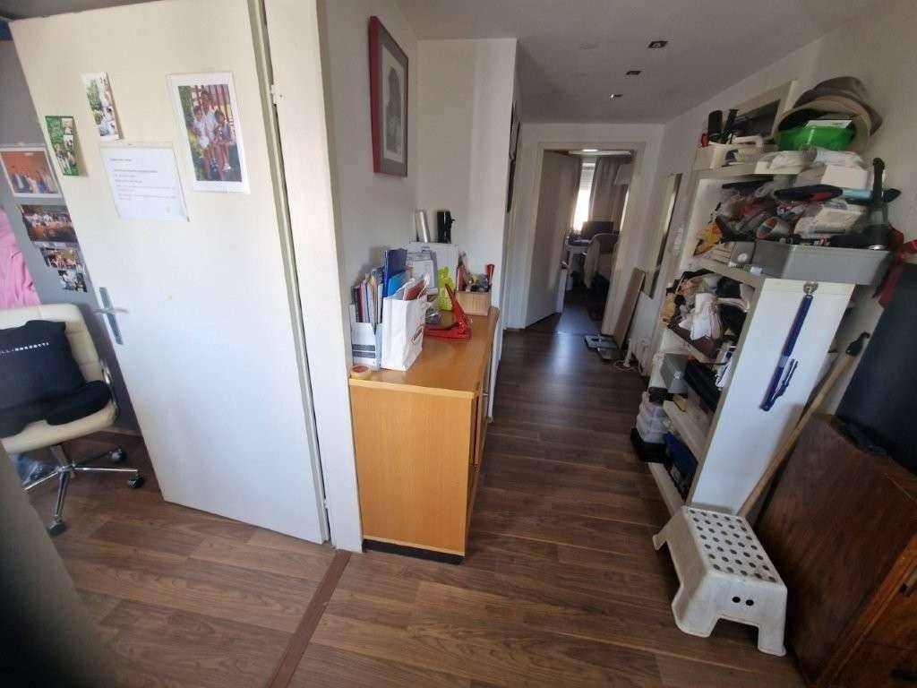 Langer Flur mit Laminatboden und Zugang zu weiteren Räumen.