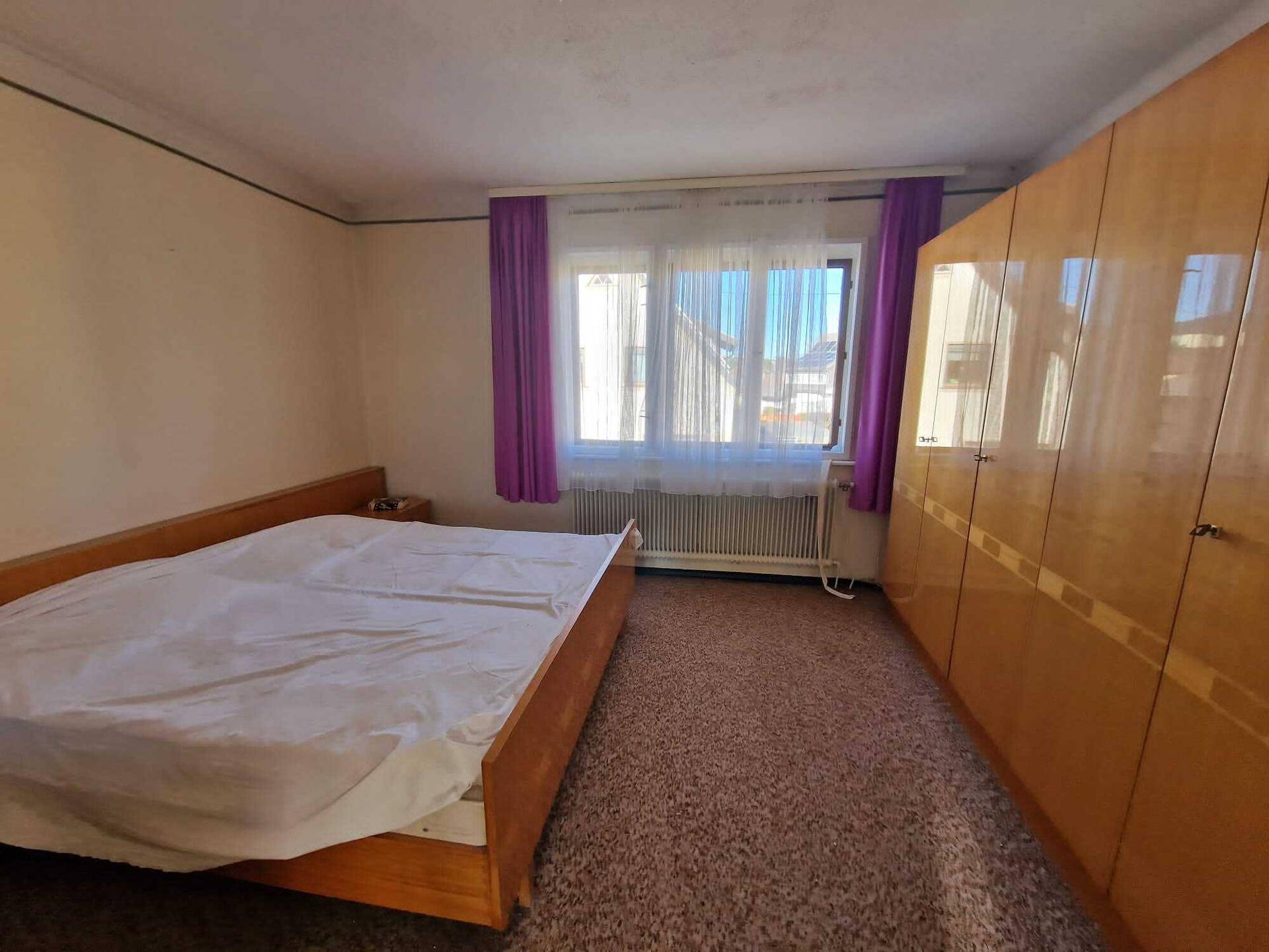 Gemütliches Schlafzimmer mit Teppichboden, Doppelbett und großem Kleiderschrank.