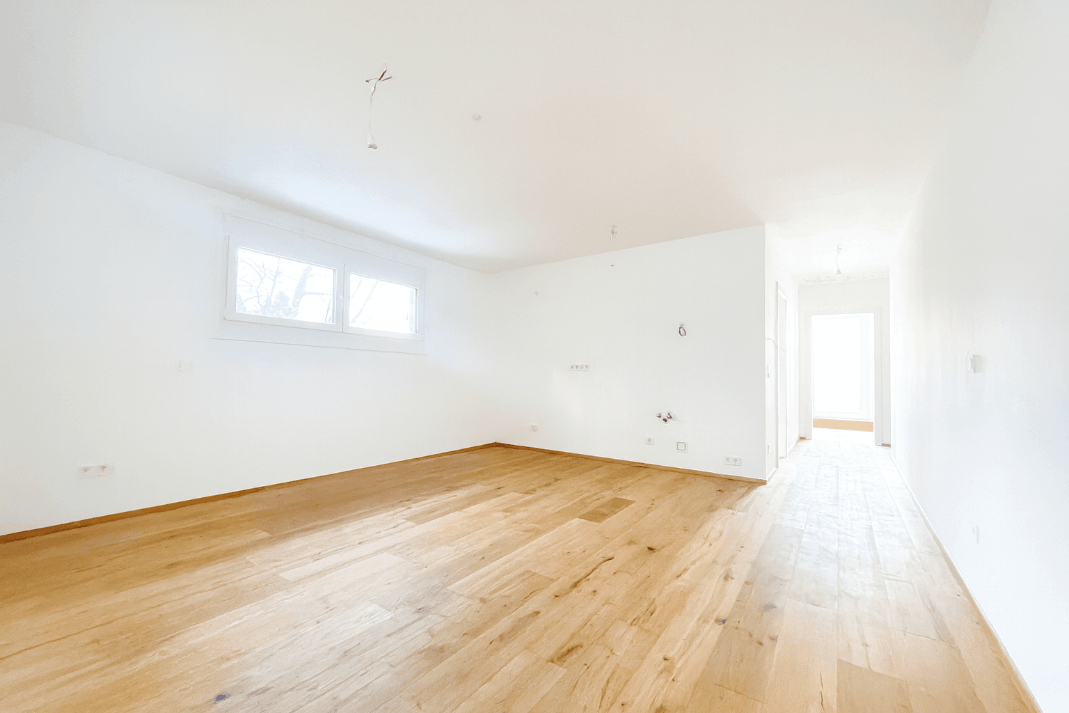 Kleiner Balkon mit Fliesenboden und Metallgeländer, umgeben von einer grünen Hanglage.