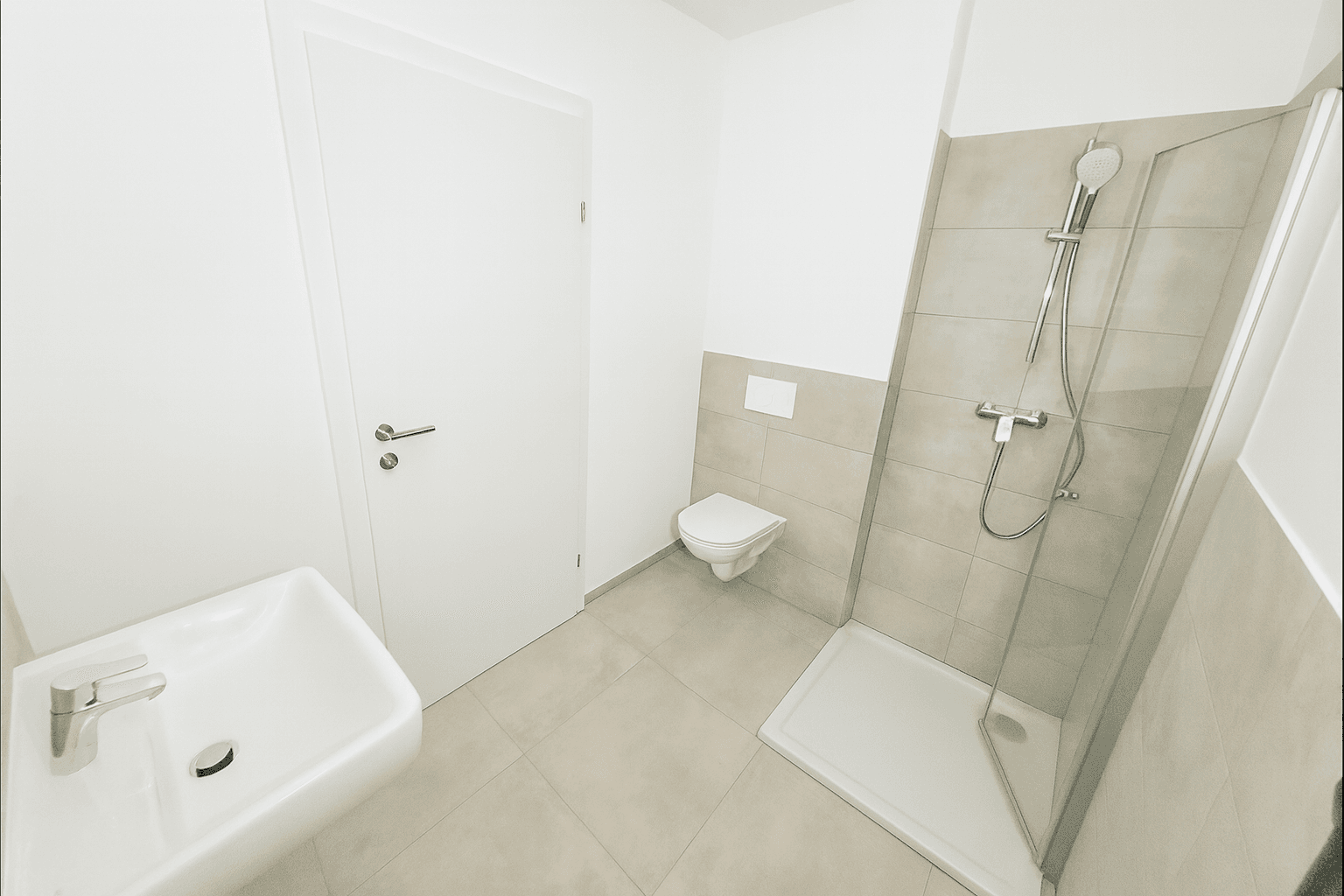 Modernes Badezimmer mit Dusche, Waschbecken und Wand-WC in neutralen Beigetönen und Fliesen.