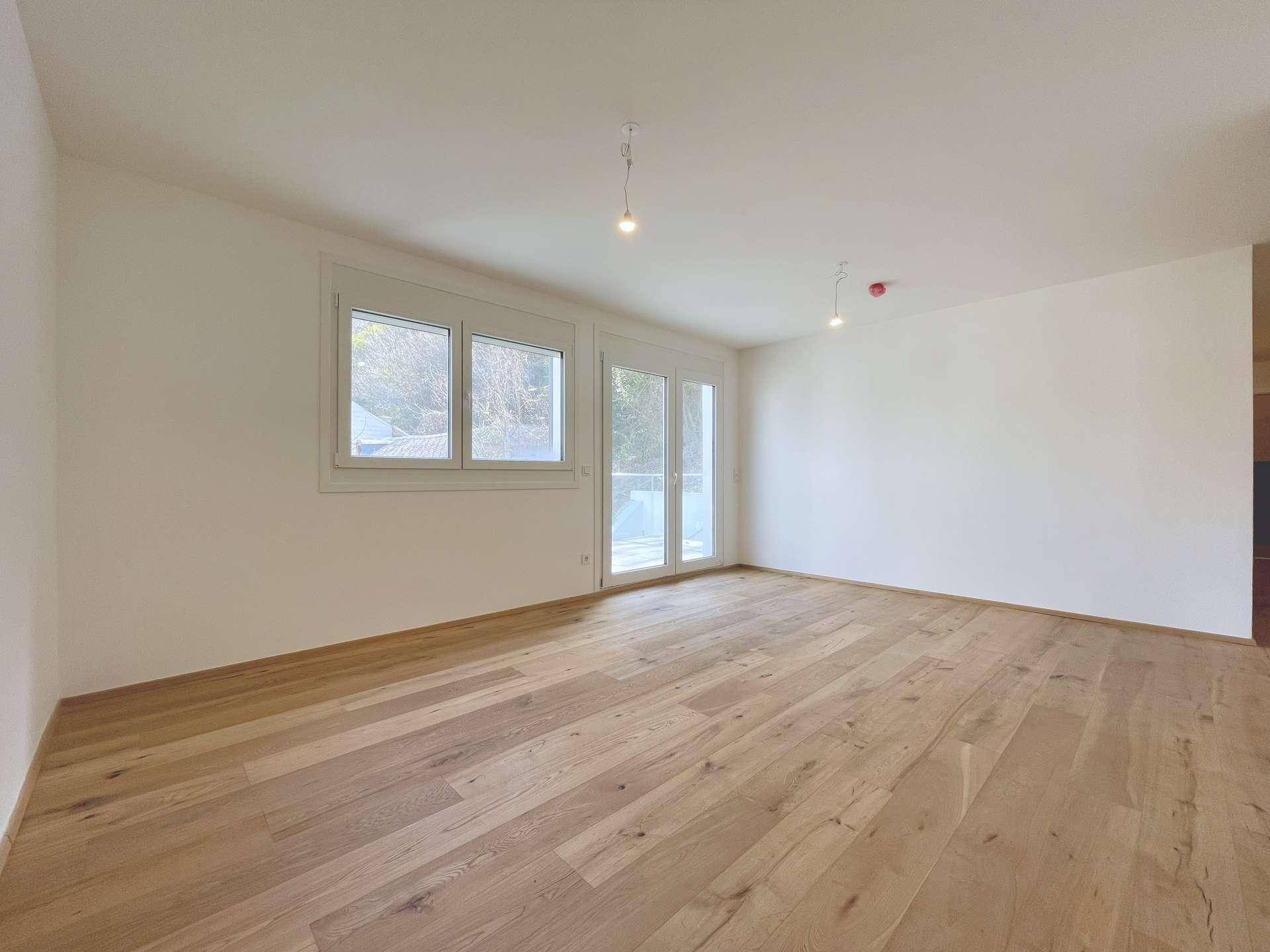 Geräumiges, leeres Zimmer mit hellen Wänden und hochwertigem Holzboden, ideal für individuelle Gestaltung.