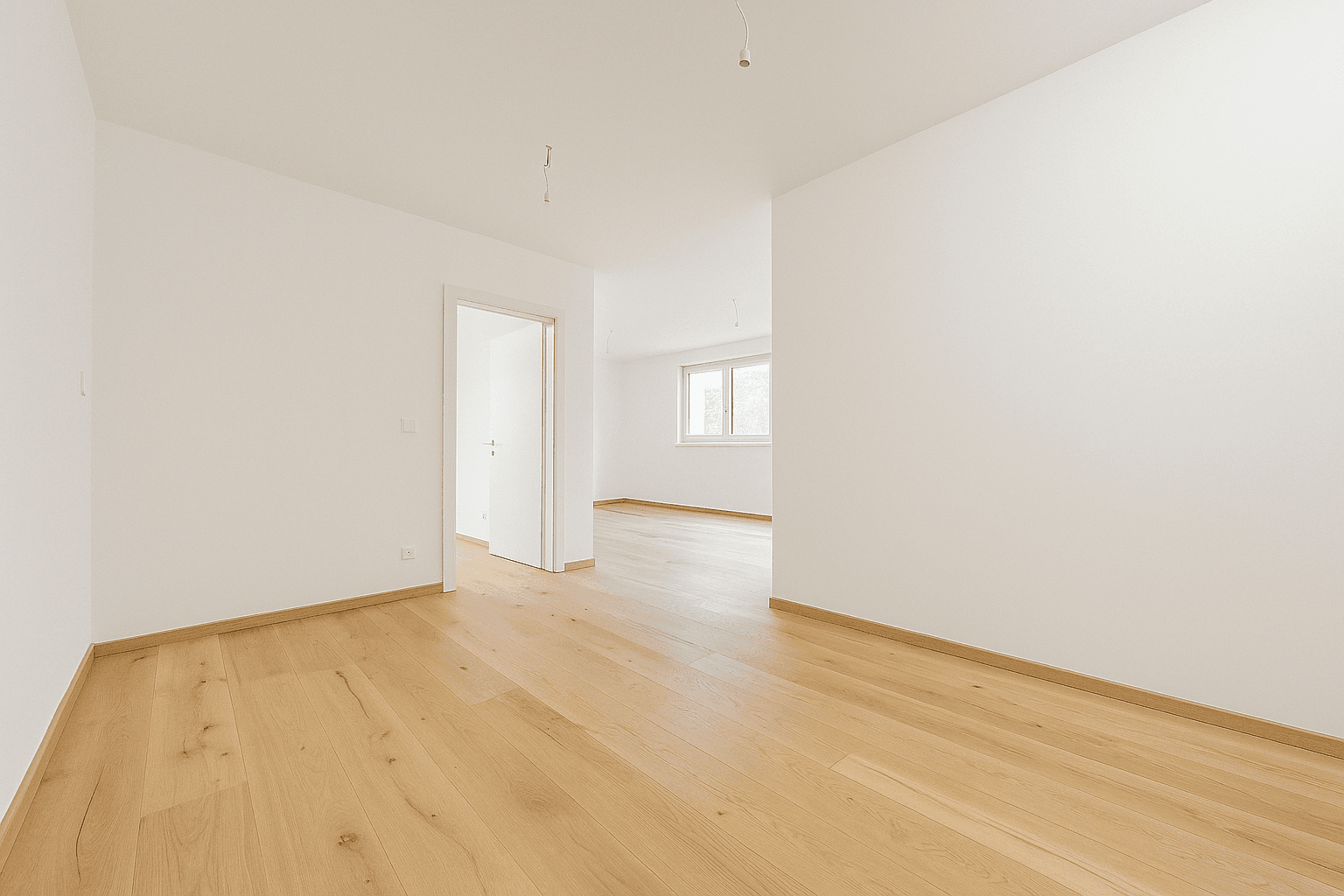 Geräumiger, heller Wohnbereich mit Holzboden und Zugang zu weiteren Räumen, bereit zur Gestaltung.