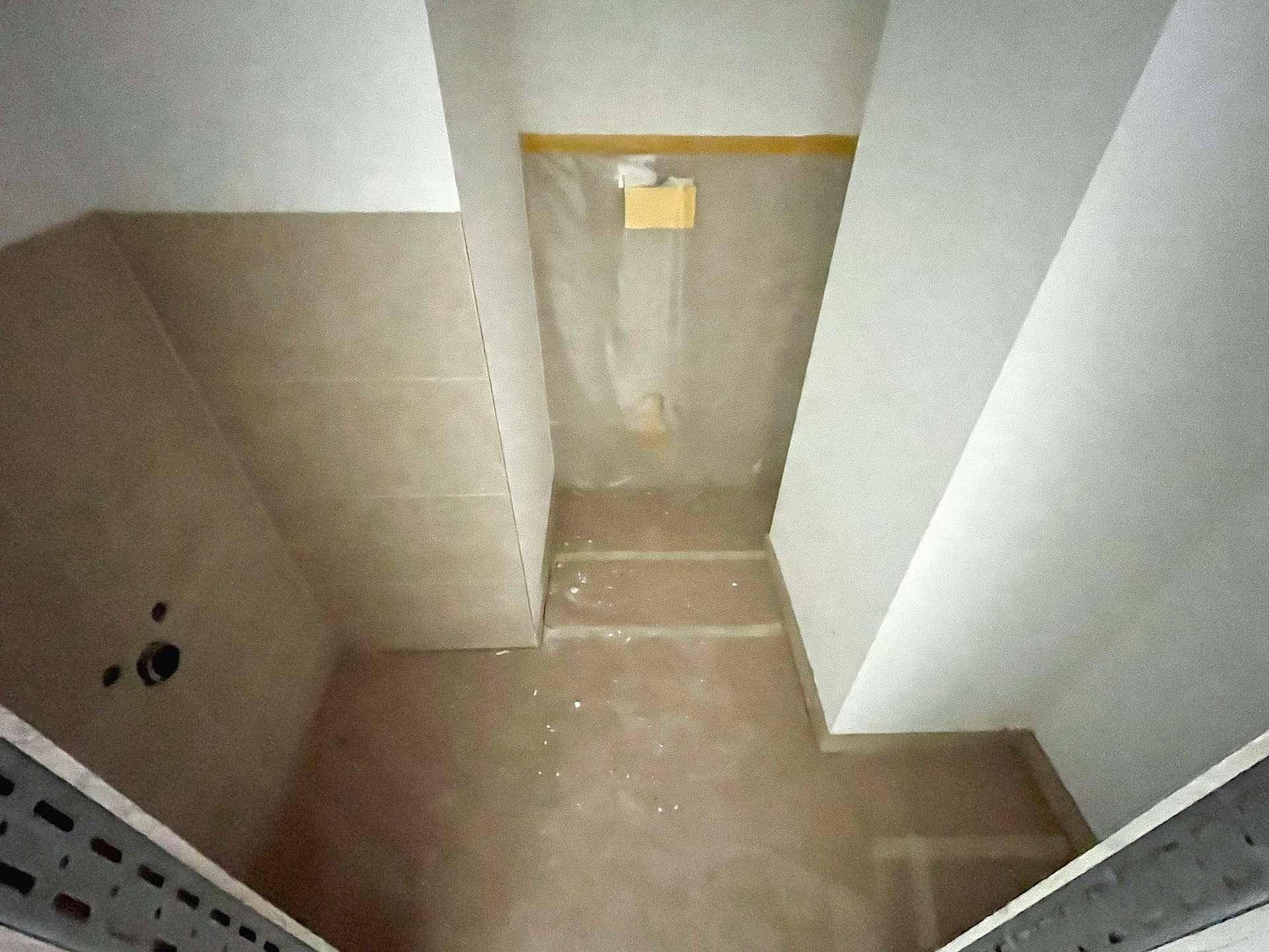 Schmaler Raum mit schrägen Wänden und Fliesen, möglicherweise eine Duschkabine im Dachgeschoss.