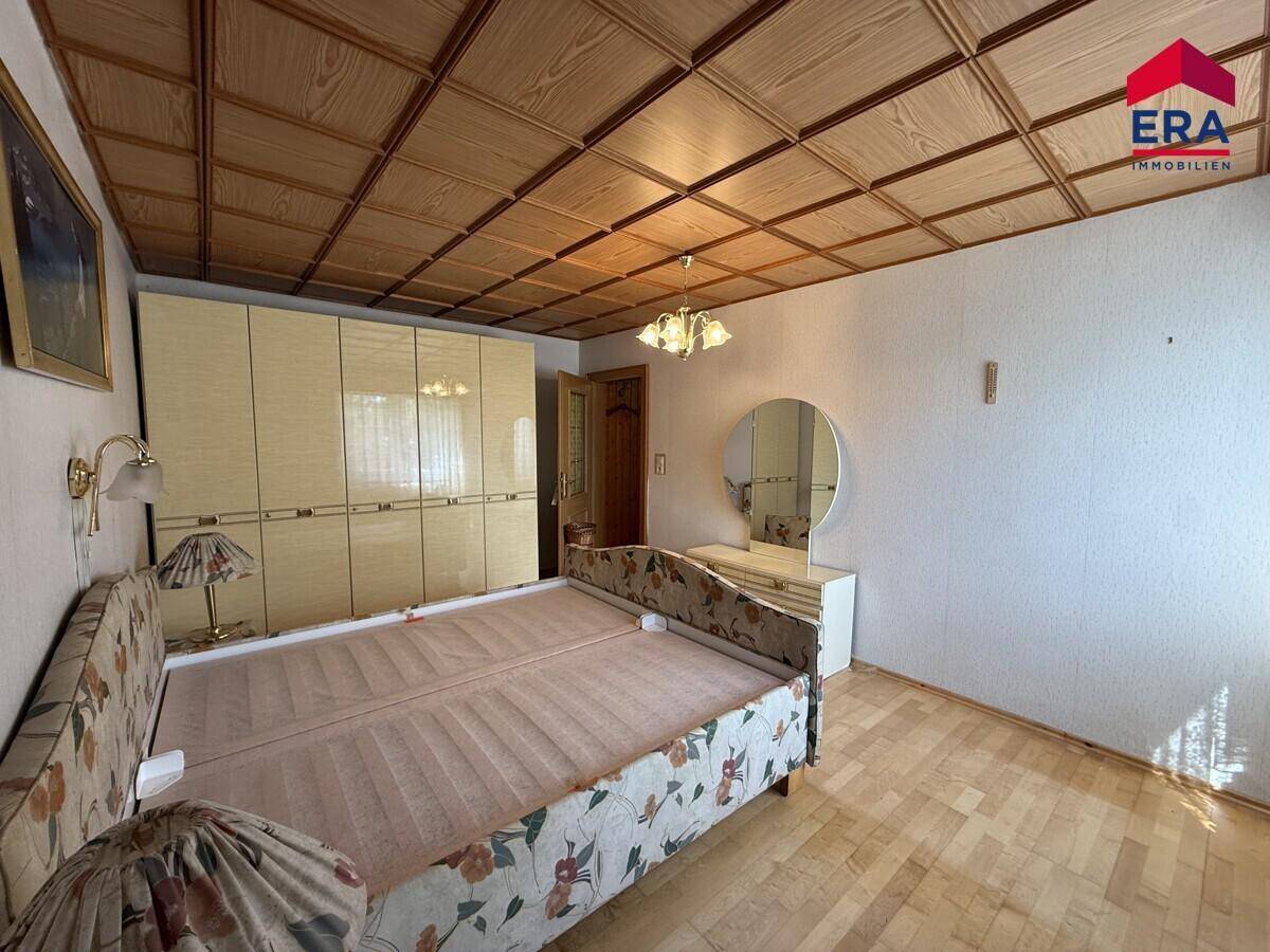 Schlafzimmer mit Holzfußboden, Doppelbett und einem großen, hellen Kleiderschrank.