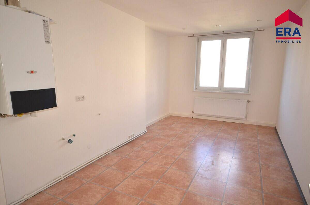 Funktionaler Raum mit Terrakotta-Fliesenboden und Wandheizung, ideal als Hauswirtschaftsraum oder kleine Küche.