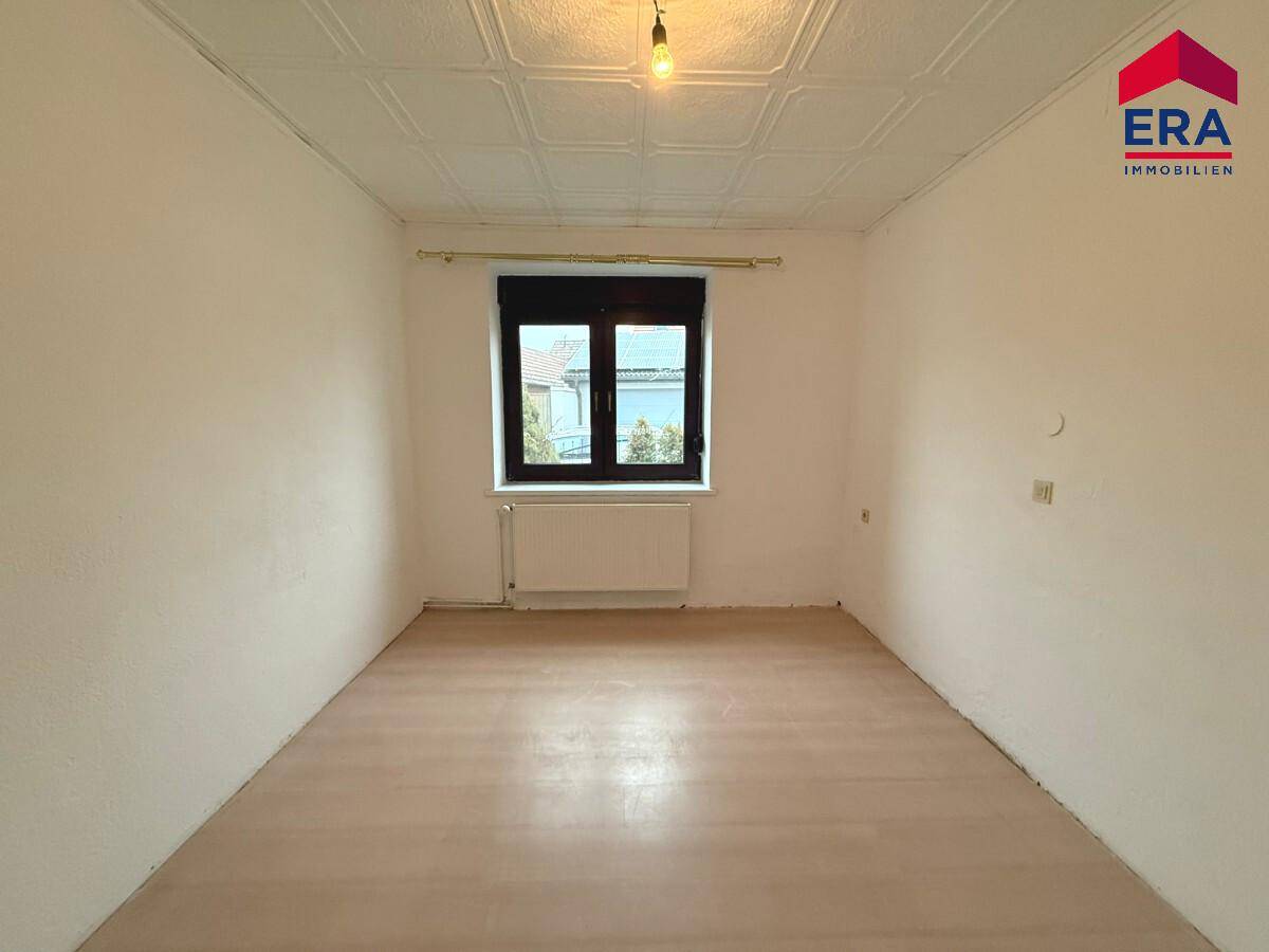 Heller, leerer Raum mit Laminatboden und Fenster, vielseitig nutzbar als Schlaf- oder Arbeitszimmer.