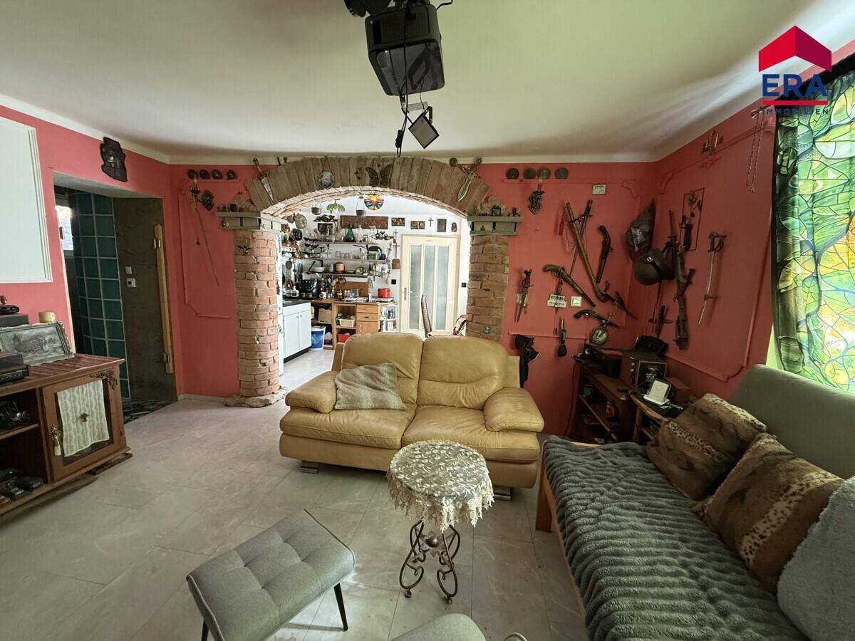 Geräumiges Wohnzimmer mit zwei Sofas und einem markanten Ziegelbogen, der den Raum gliedert.