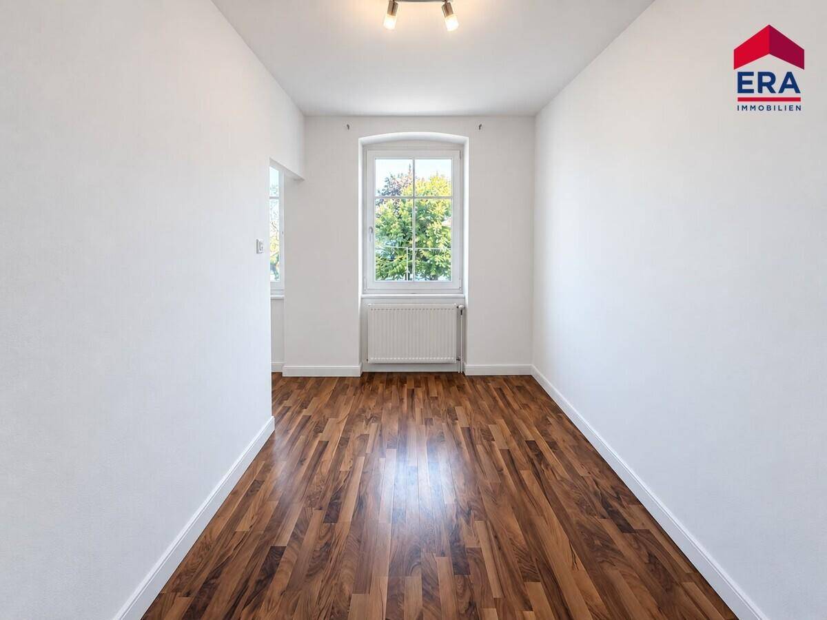 Gemütliches Zimmer mit Laminatboden und einem Fenster, perfekt als Kinder- oder Gästezimmer.