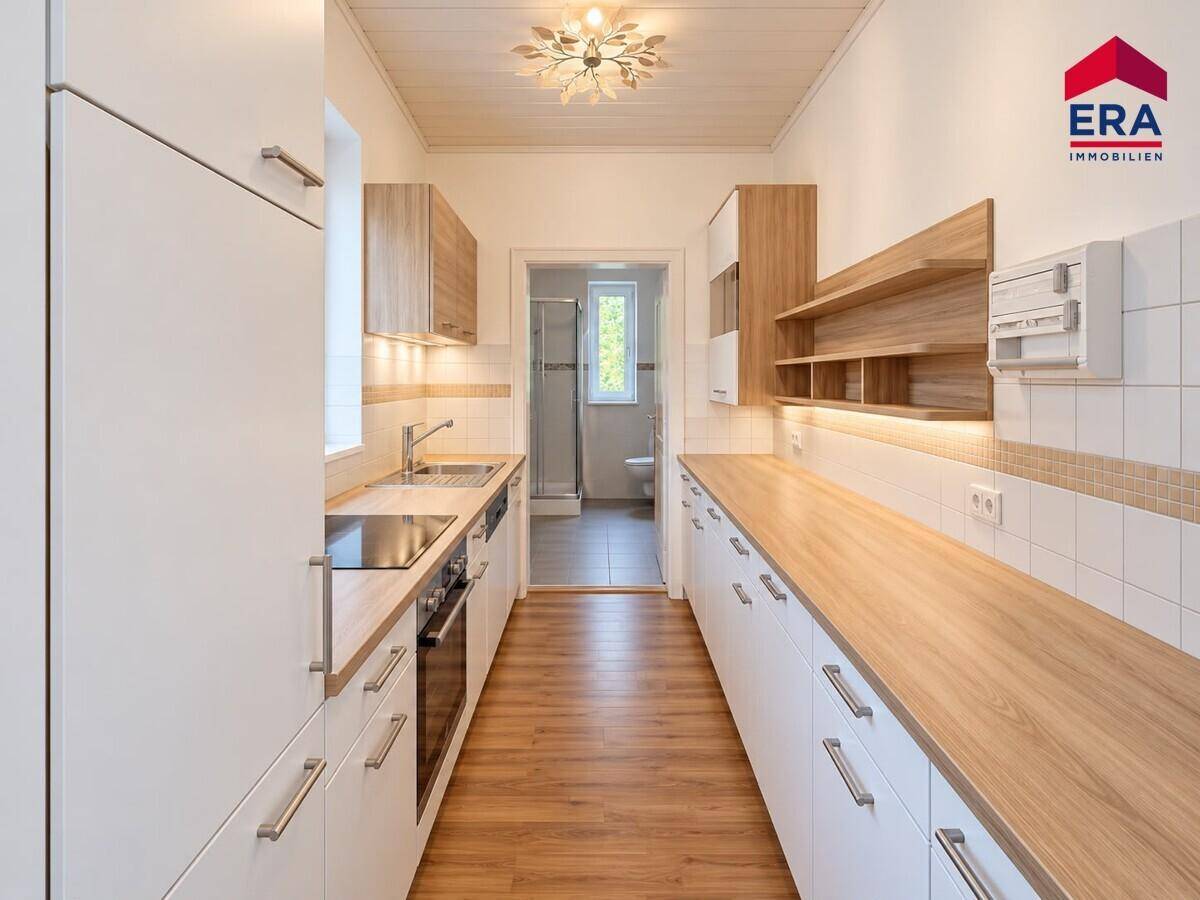 Funktionale Küche mit viel Stauraum, Holz-Arbeitsplatten und Blick in den angrenzenden Raum.