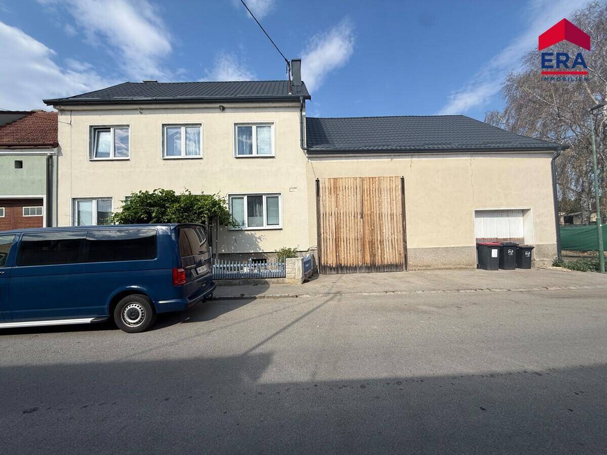 Vorderansicht des Gebäudes von der Straße mit einem geparkten blauen Transporter.