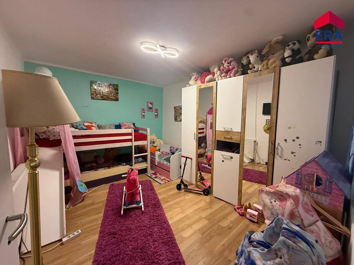 Kinderzimmer mit Etagenbett, großem Kleiderschrank und Teppichboden.