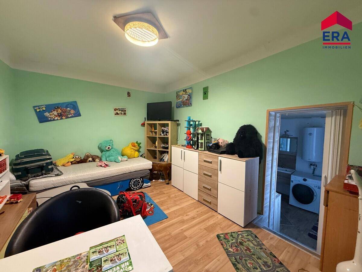Buntes Kinderzimmer mit Bett, Spielzeug und Schränken, ideal für junge Bewohner.
