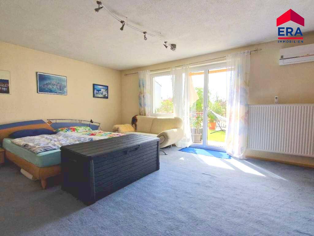 Schlafzimmer mit Teppichboden, Bett und Zugang zu einem Außenbereich mit Hängematte.