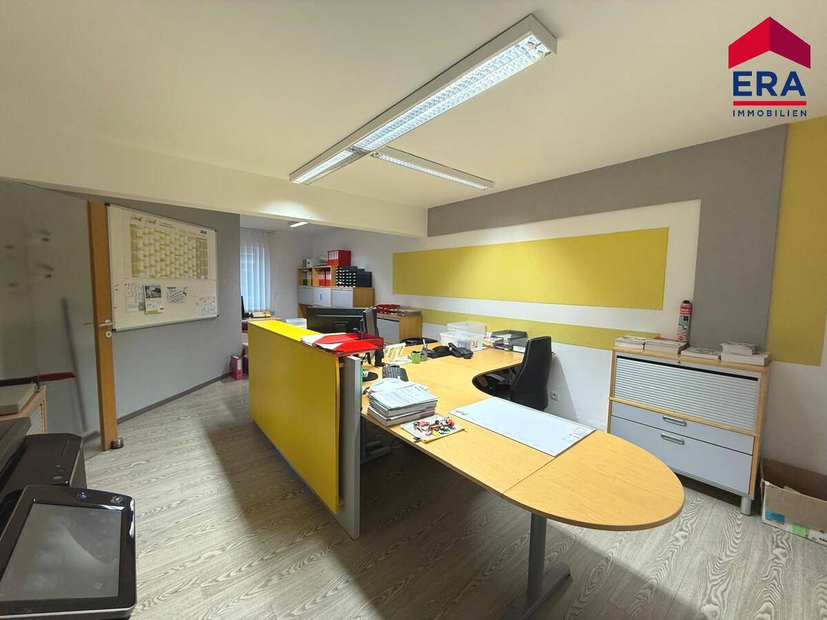 Helles Büro mit modernem Schreibtisch, gelben Akzentwänden und funktionaler Büroeinrichtung.
