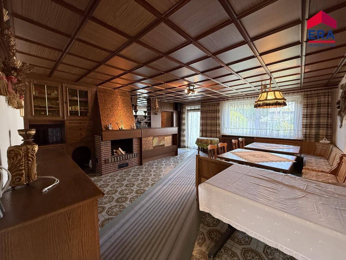 Gemütlicher Wohn- und Essbereich mit Kamin, Holzmöbeln und einer Kassettendecke.