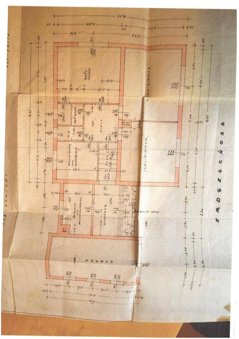 Historischer Grundriss des Erdgeschosses mit Garage, Balkon und mehreren Zimmern.