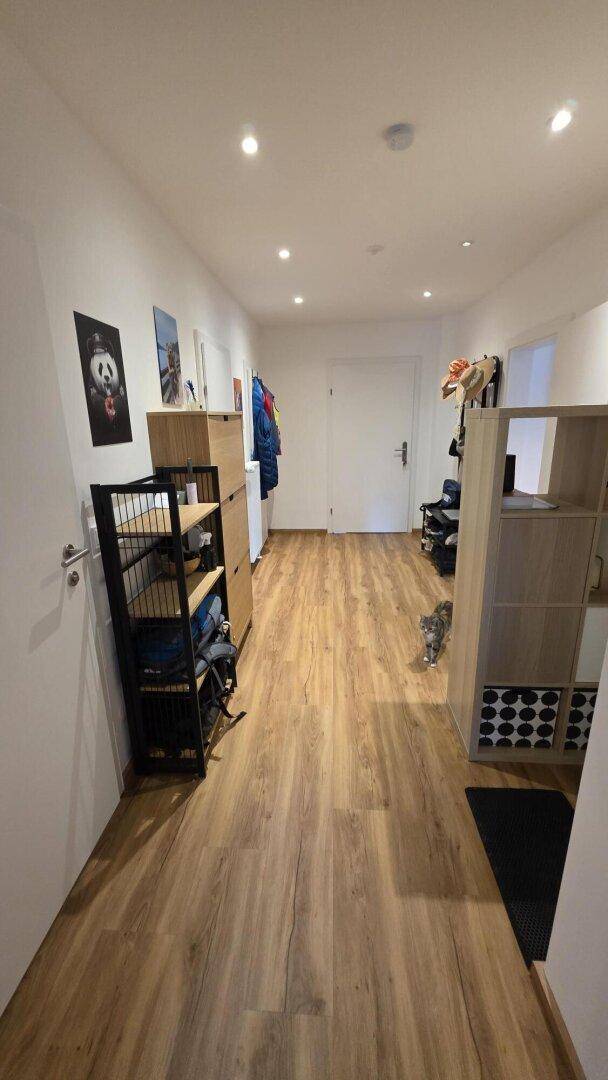 Heller Flur mit Laminatboden, Einbauschränken und Garderobe, führt zu weiteren Räumen.
