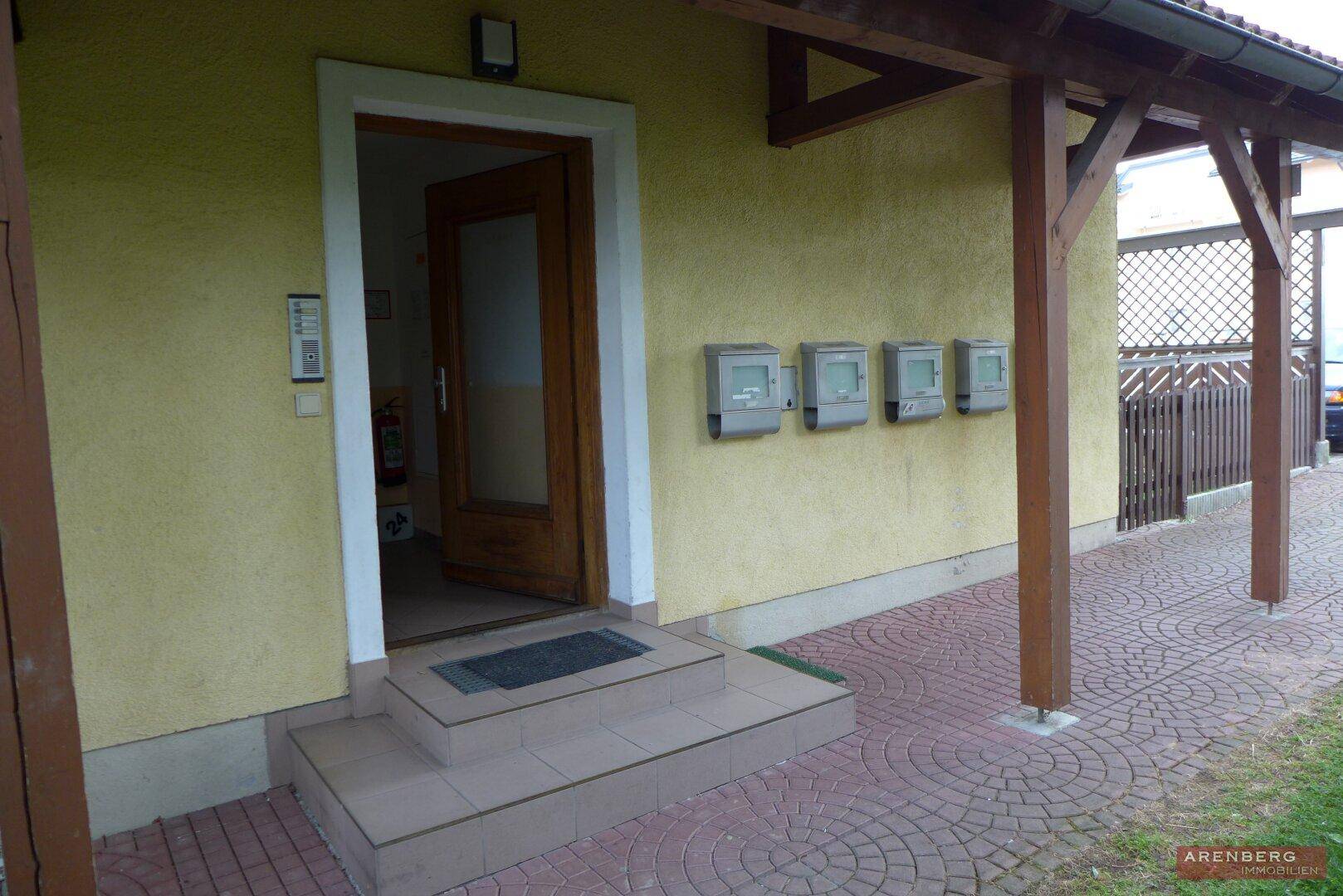 Eingangsbereich des Hauses mit Briefkästen und überdachtem Zugang.
