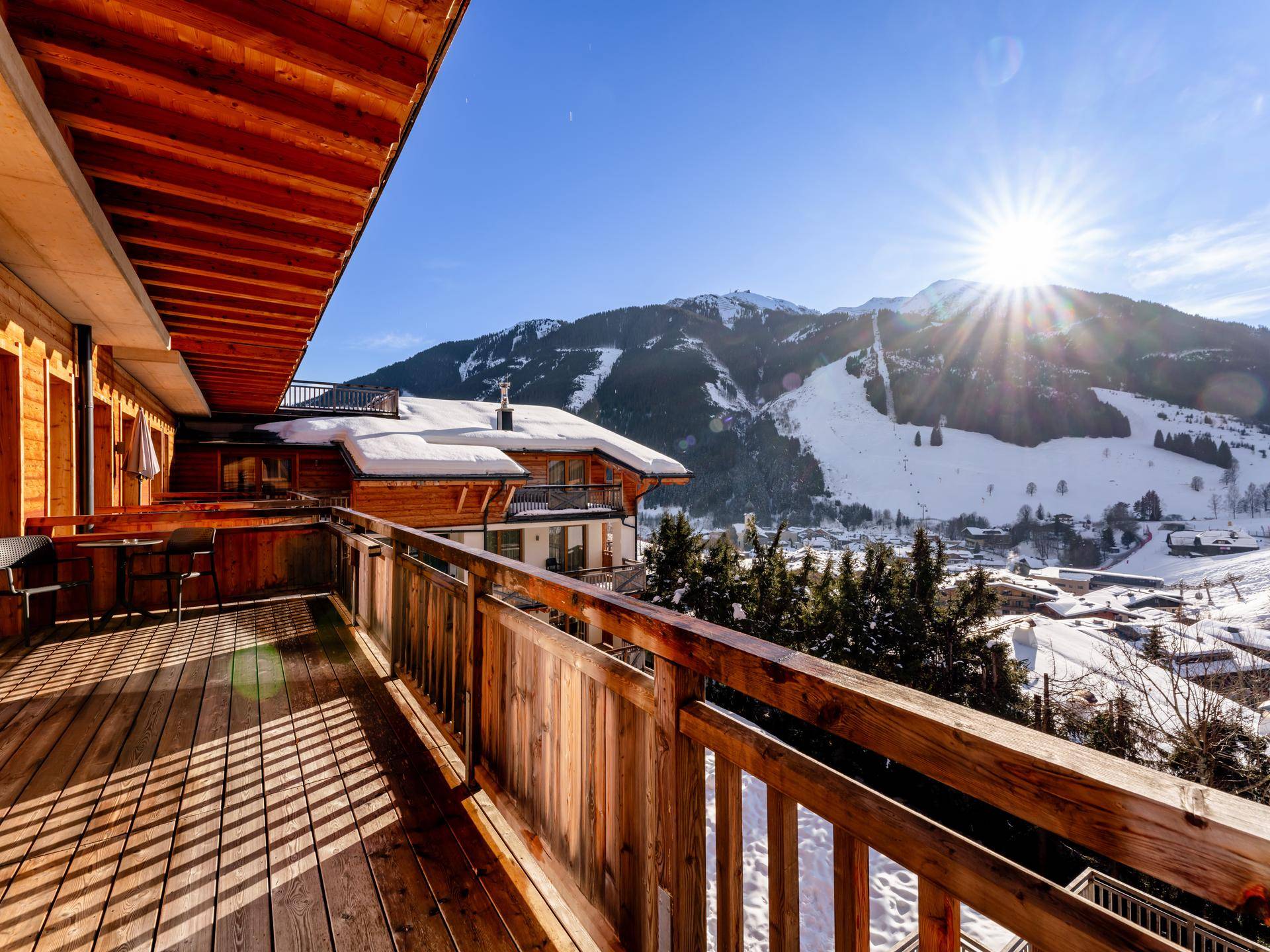 Großer Holzbalkon mit atemberaubendem Blick auf die verschneiten Berge und das Tal.