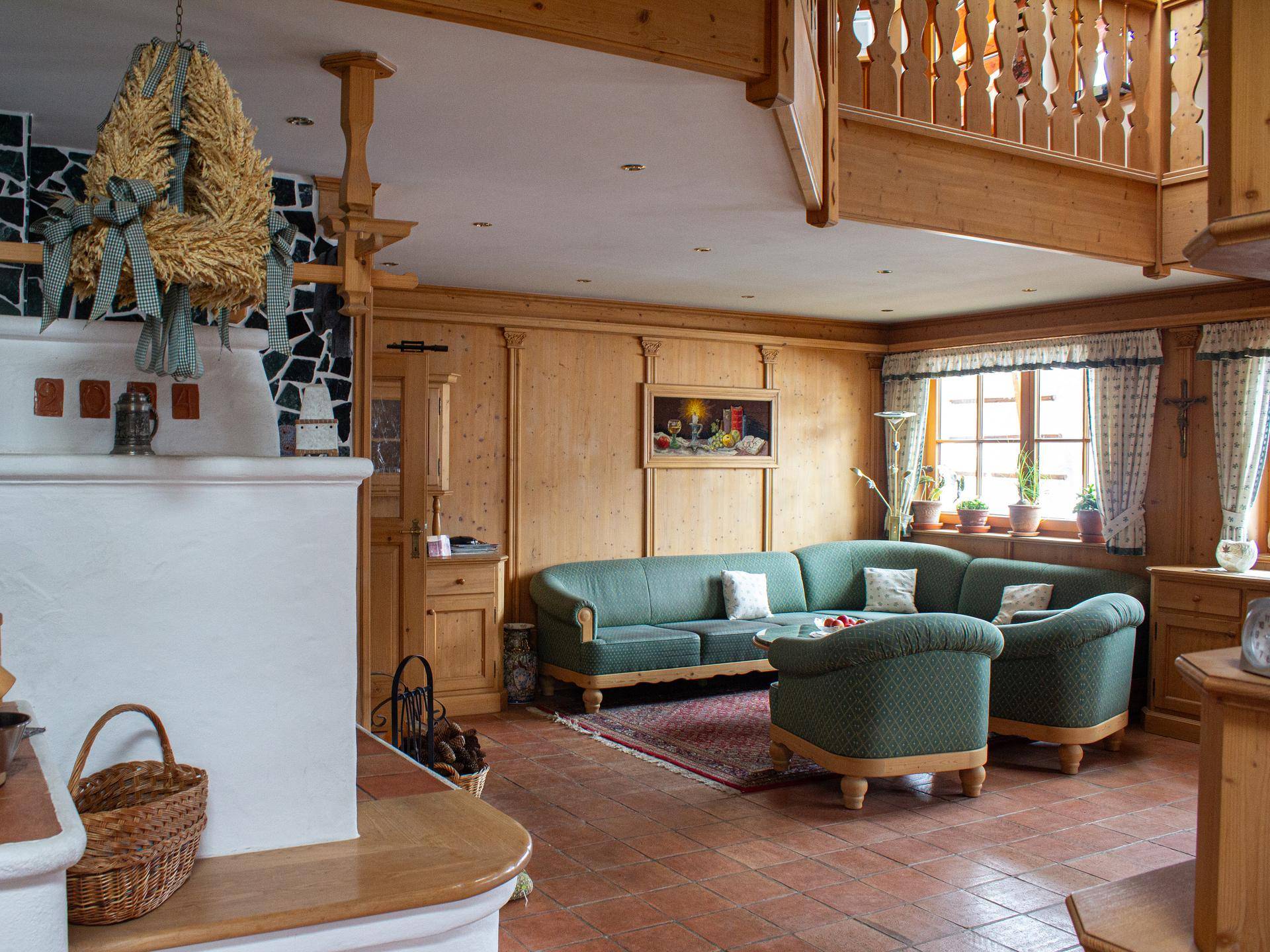 Gemütliches Wohnzimmer im Landhausstil mit grünem Sofa, Kamin und Holzvertäfelung.