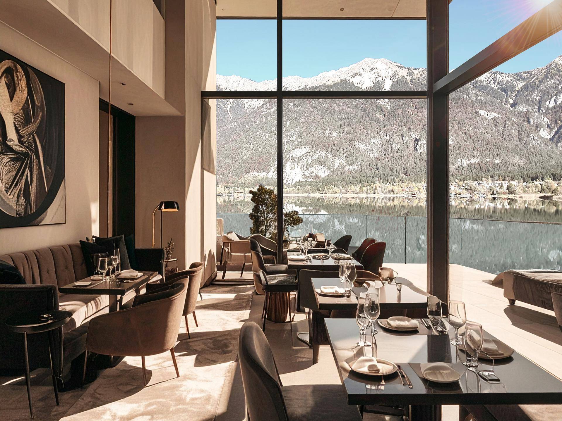 Eleganter Essbereich mit Seeblick, großen Fenstern und moderner Einrichtung.