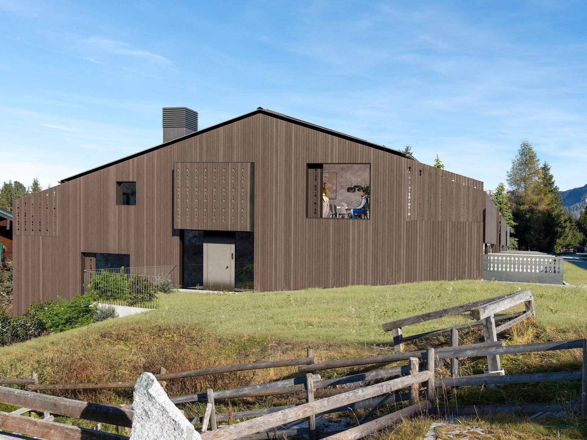 Modernes Holzhaus mit dunkler Fassade und großen Fenstern in ländlicher Umgebung.