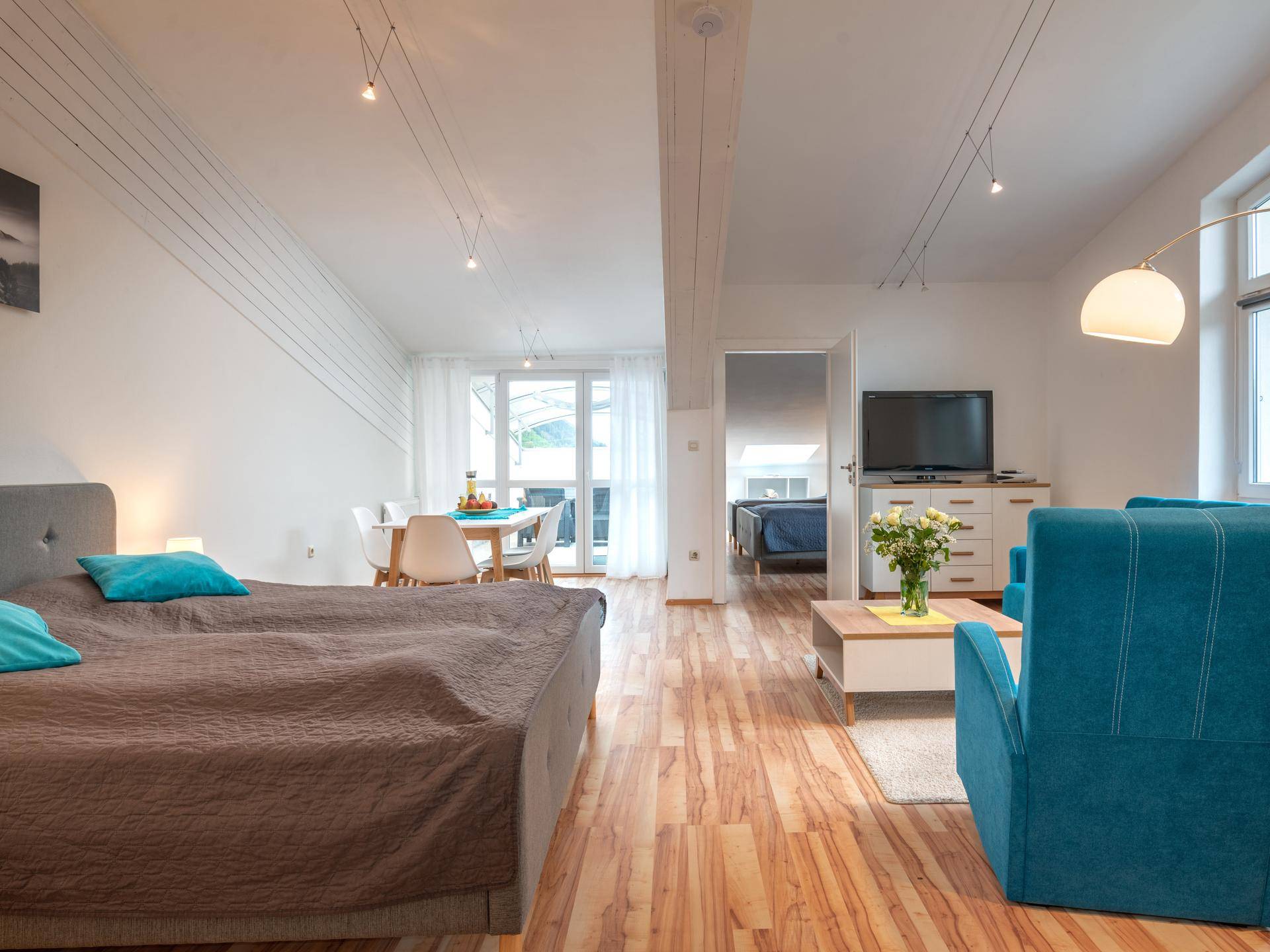 Gemütlicher Schlafbereich mit Doppelbett und offenem Zugang zum Wohn-Essbereich.