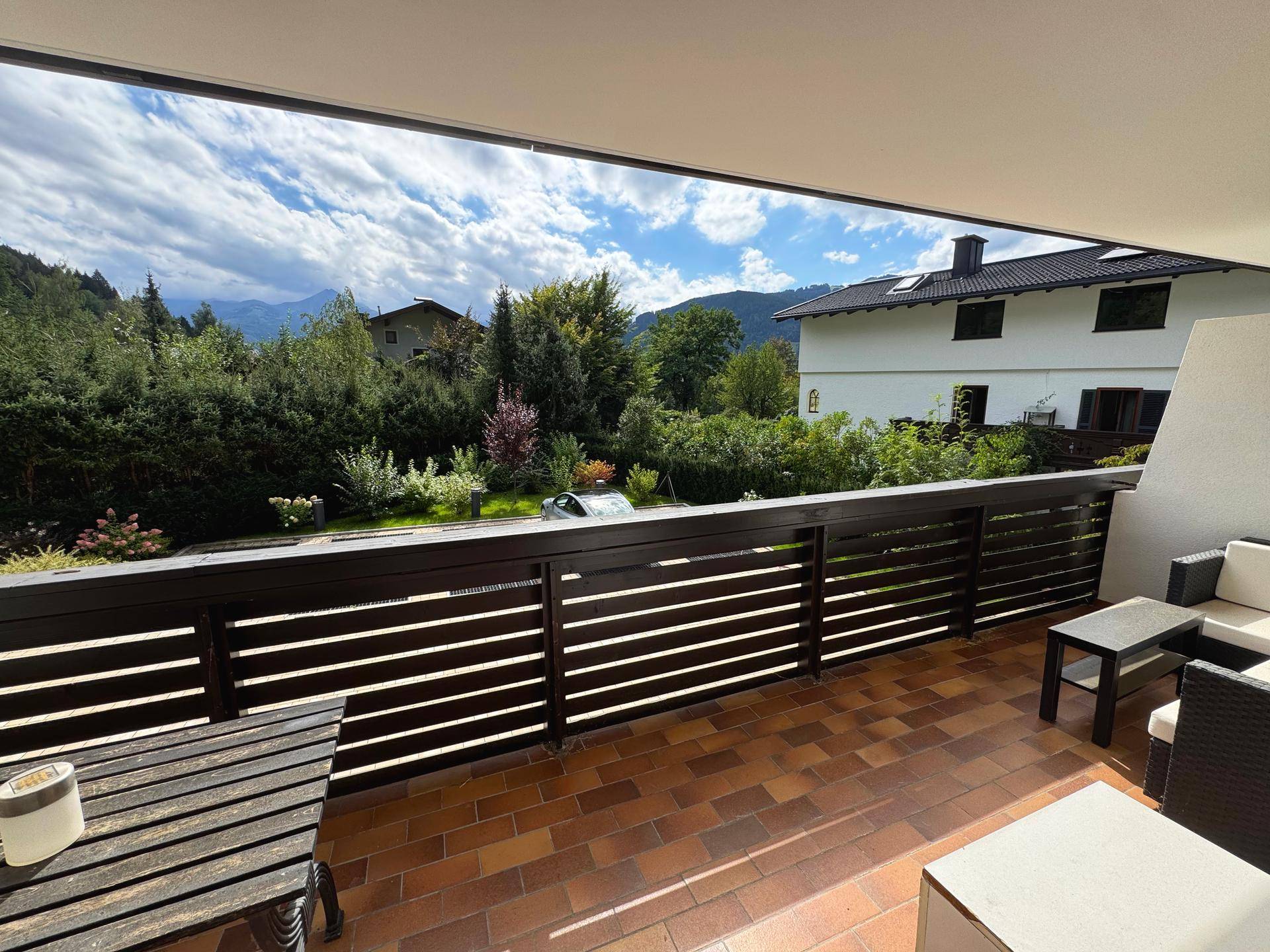 Geräumiger Balkon mit Terracotta-Fliesen und Sitzgelegenheiten, bietet einen weiten Blick auf die Berge.