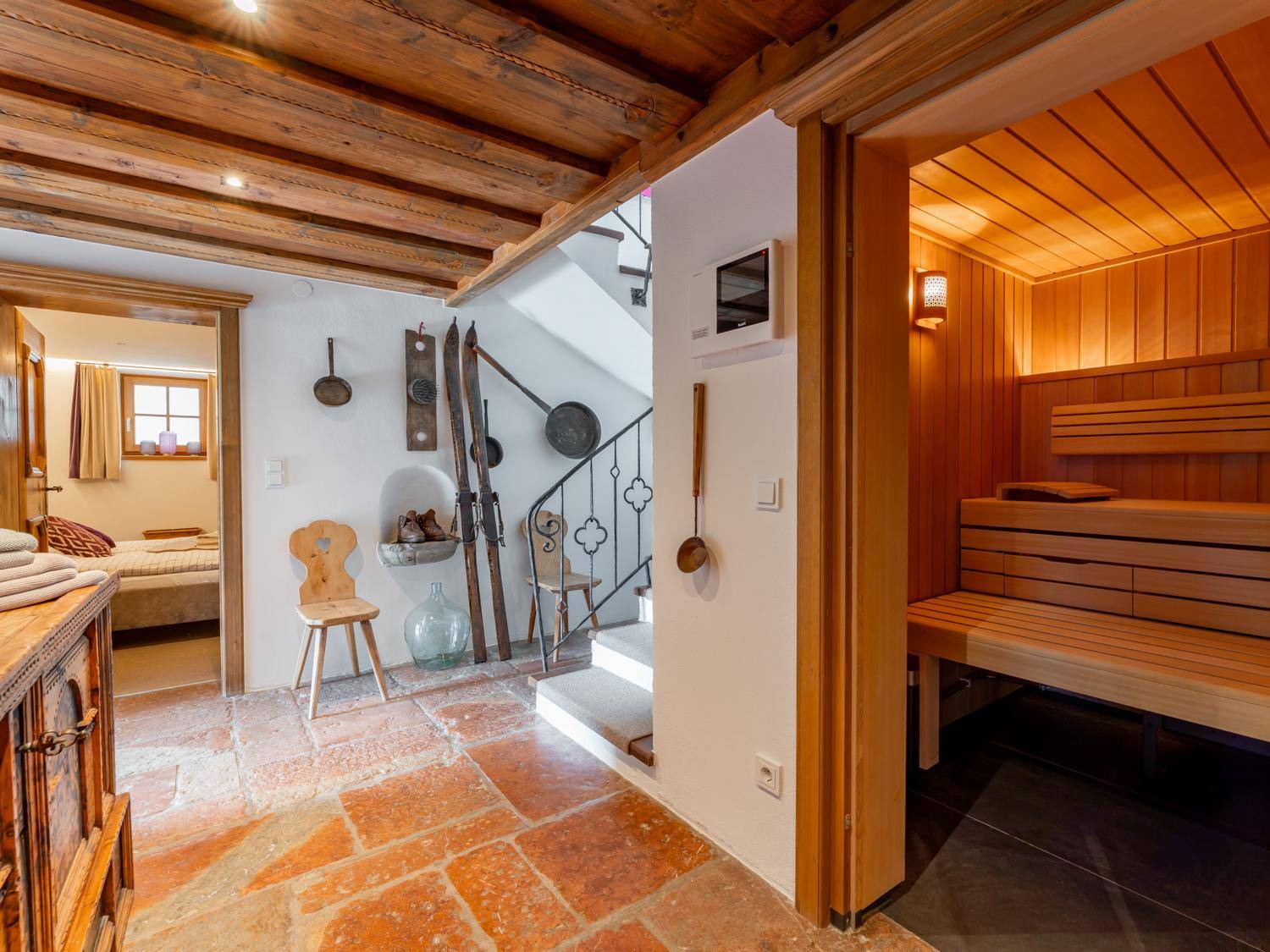 Eingangsbereich mit Steinfliesen, traditioneller Dekoration und direktem Zugang zur Sauna.