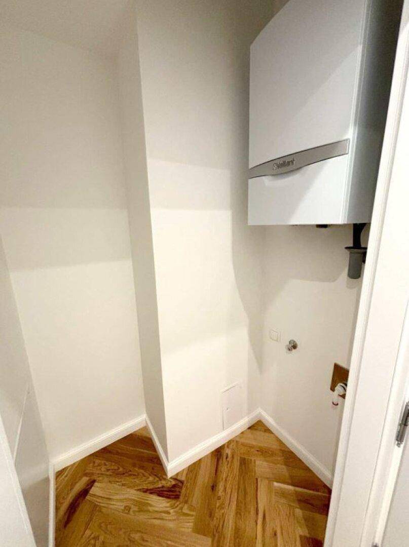 Hauswirtschaftsraum mit moderner Heizungsanlage und Fischgrätparkett, praktisch und funktional.