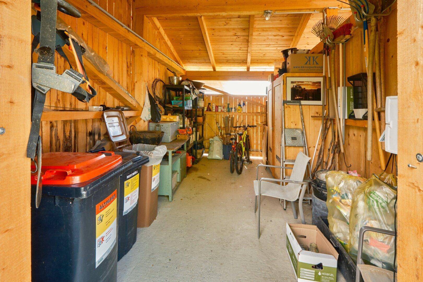 Praktischer Abstellraum mit Holzverkleidung, Regalen und verschiedenen Haushaltsgegenständen.