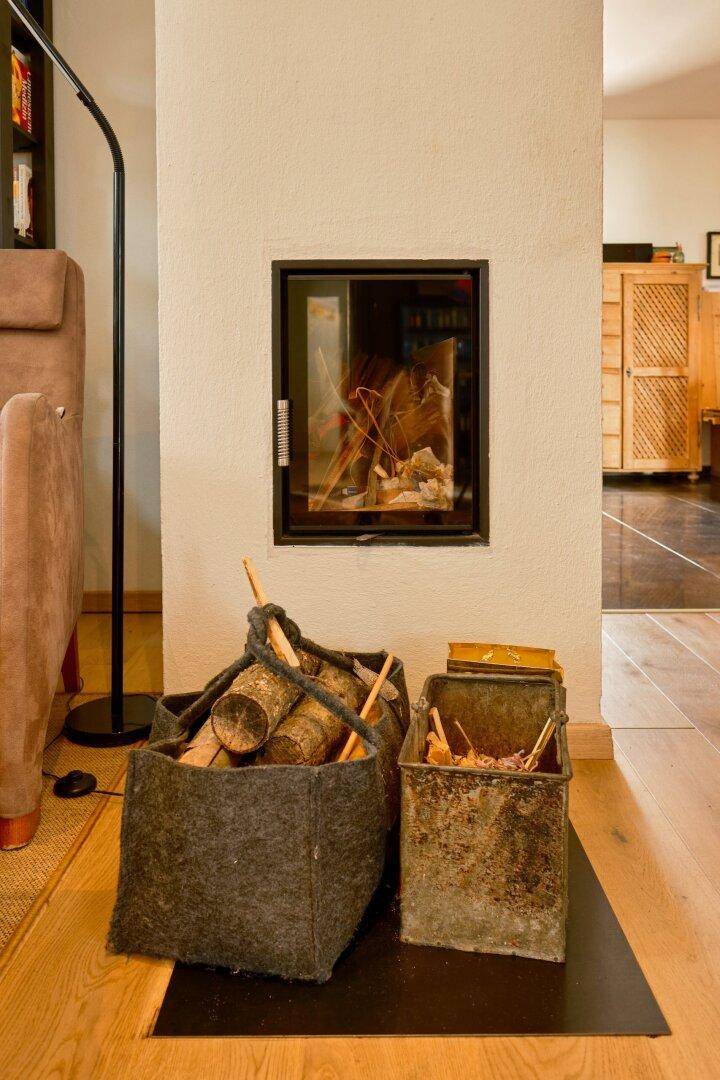 Moderner Kamin mit Holzscheiten in einem gemütlichen Wohnbereich.