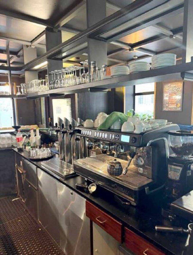 Professioneller Barbereich mit Espressomaschine, Zapfanlage und zahlreichen Gläsern und Tassen.