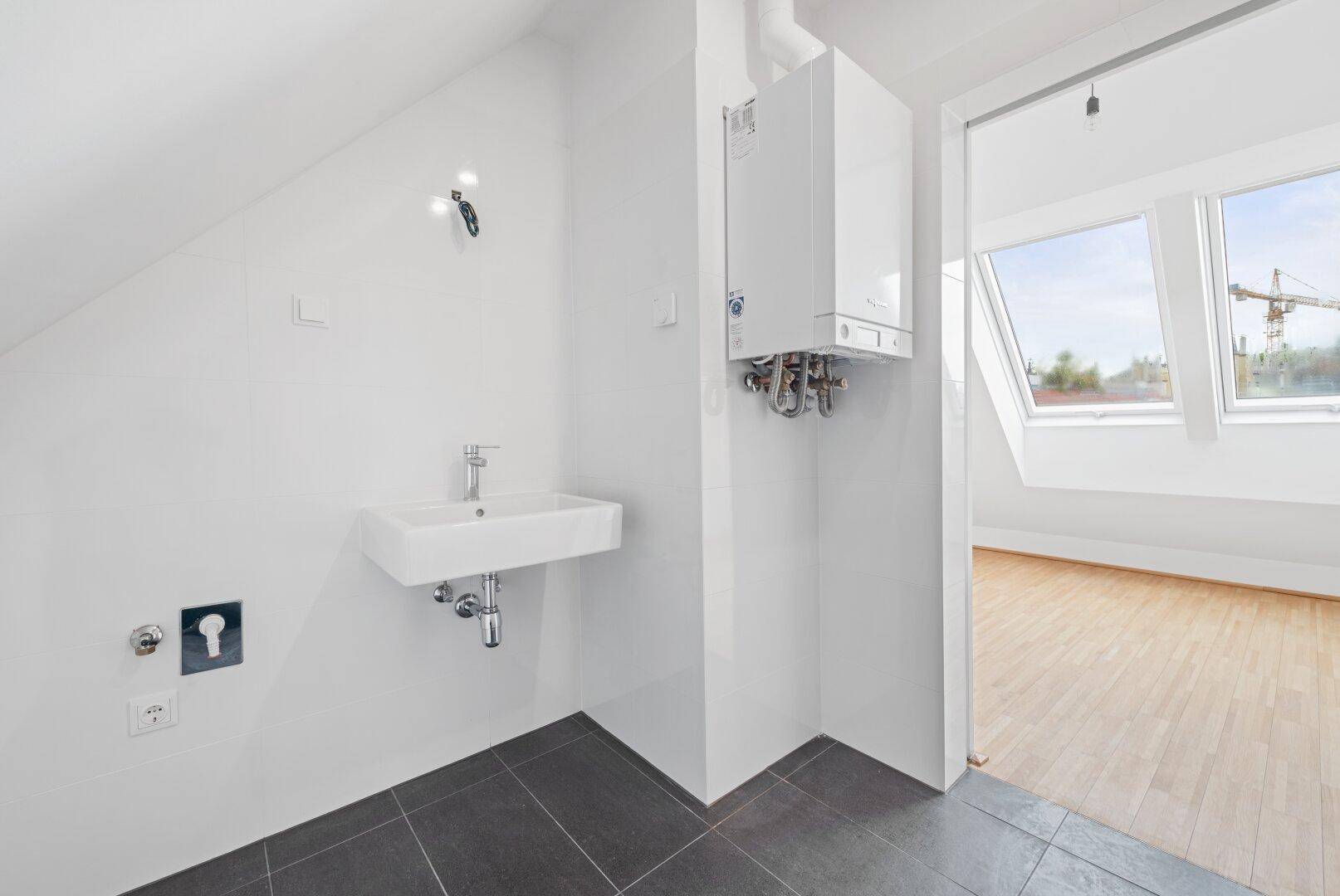 Hauswirtschaftsraum mit Waschbecken, Heizungsanlage und Fliesenboden.
