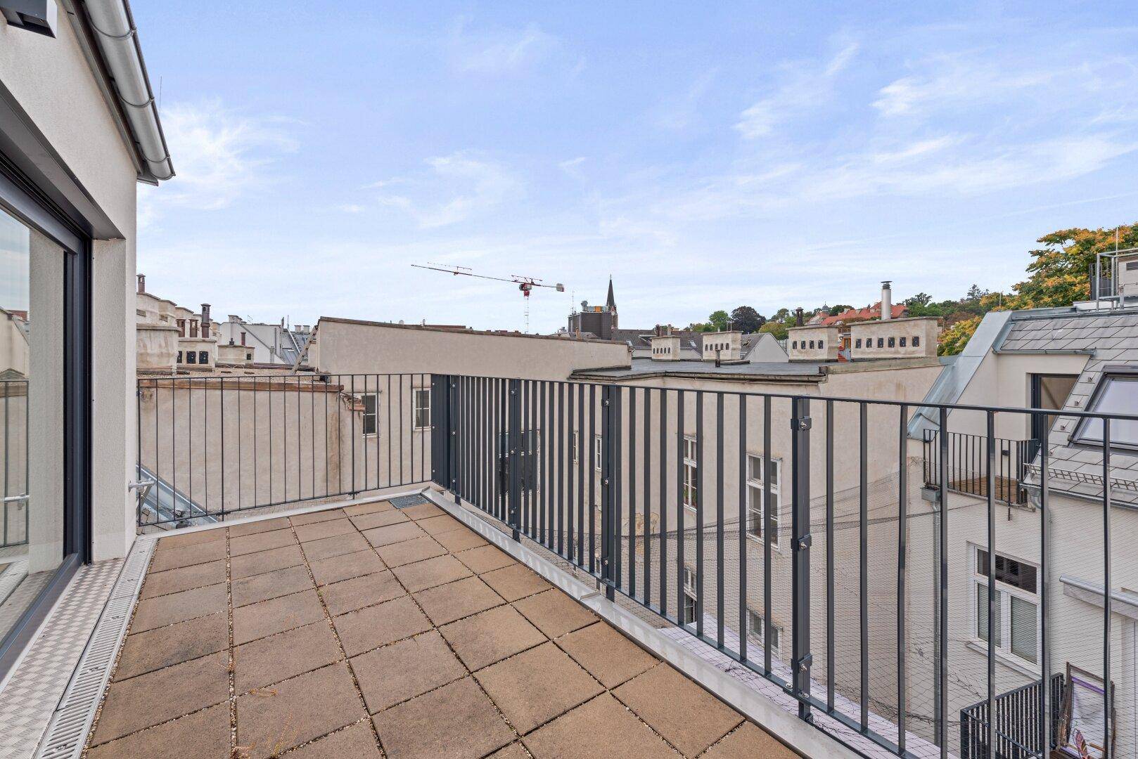 Dachterrasse mit Fliesenboden und Geländer, die einen Panoramablick bietet.