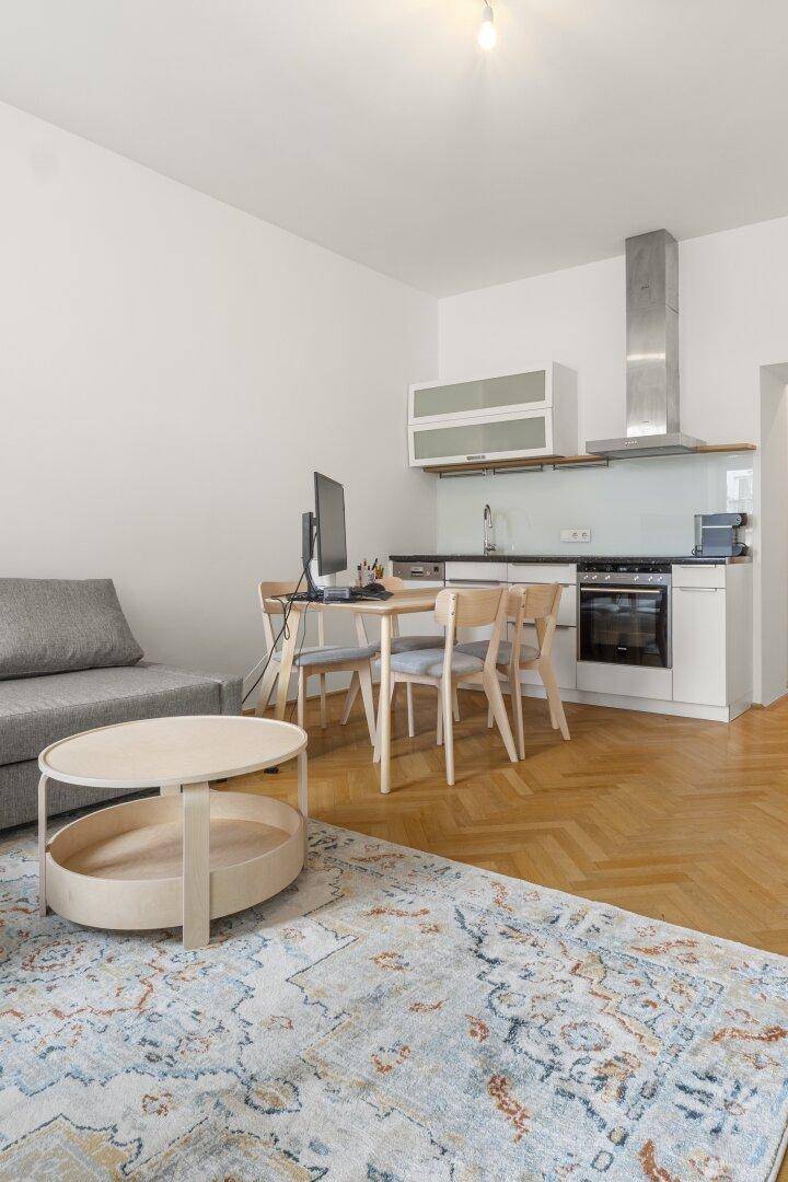 Detailansicht des Wohnbereichs mit bequemem Sofa, Couchtisch und stilvollem Teppich.