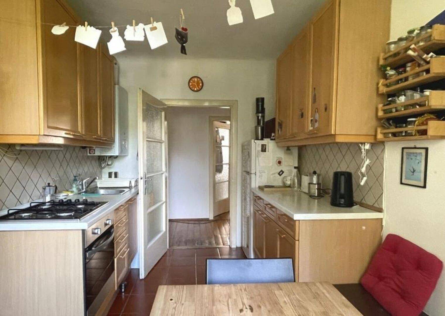 Funktionale Küche mit Holzschränken, Gasherd und Essbereich.