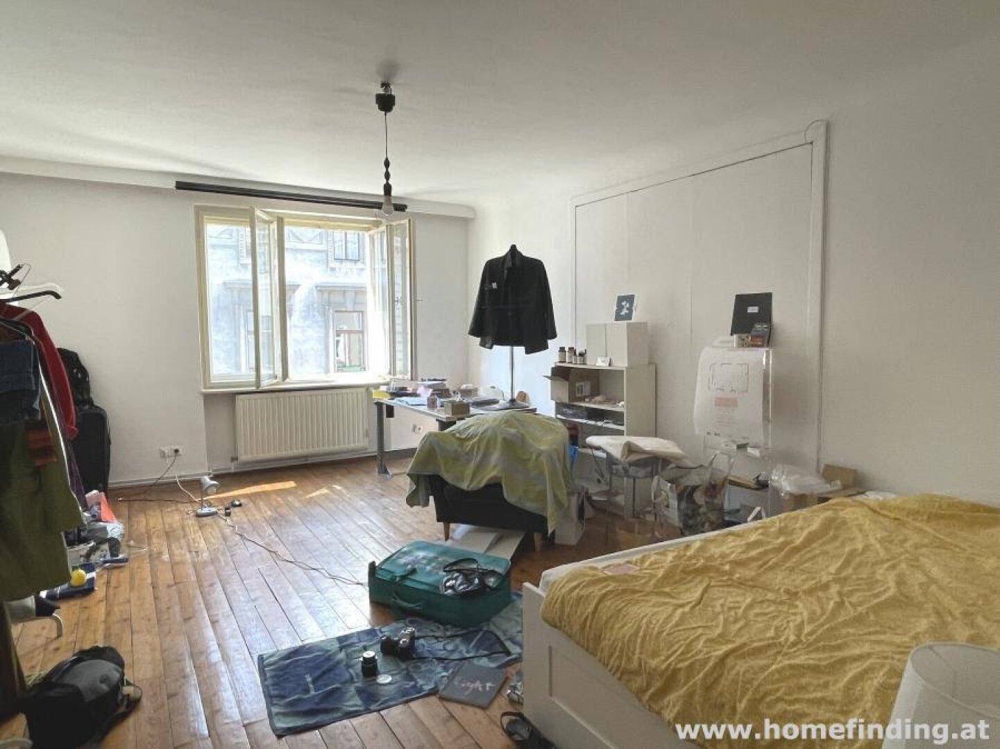 Geräumiges Zimmer mit Holzboden, Bett und Blick auf die Umgebung.