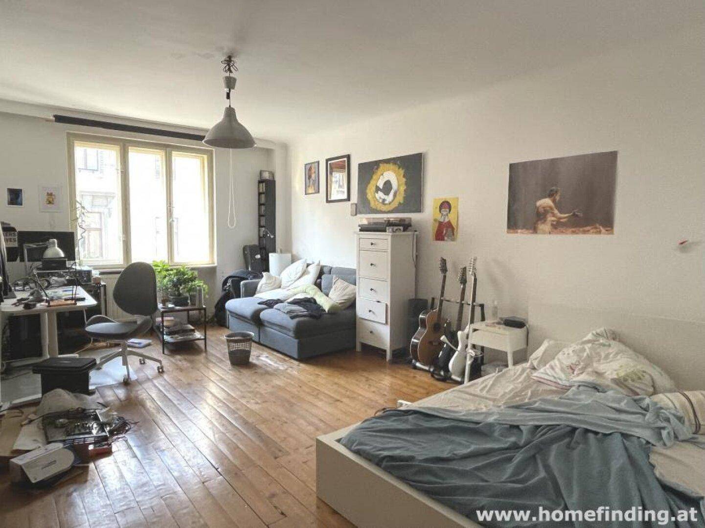 Helles Schlafzimmer mit Holzboden, Bett und Sofa, ideal für Studenten.