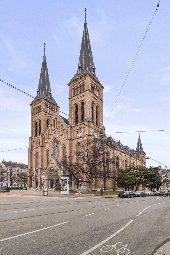 Beeindruckende Kirche mit zwei Türmen im Stadtzentrum, umgeben von städtischer Architektur.