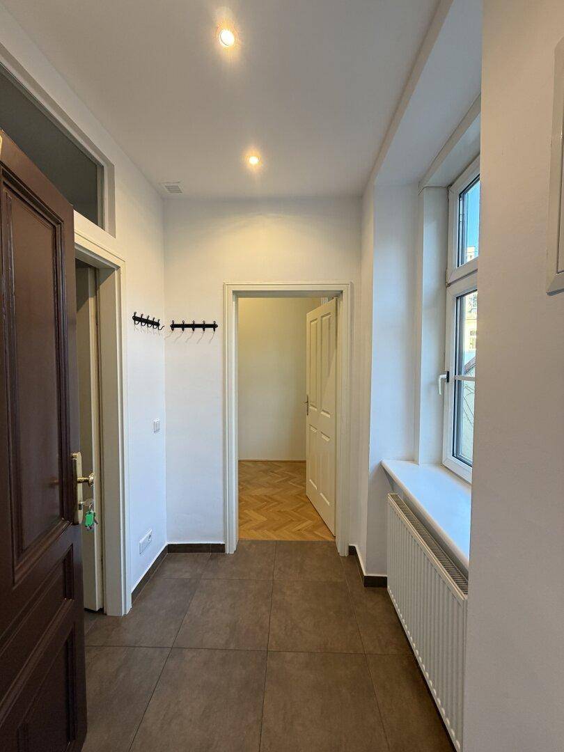 Eingangsbereich mit Fliesenboden, Garderobe und Zugang zu weiteren Räumen.