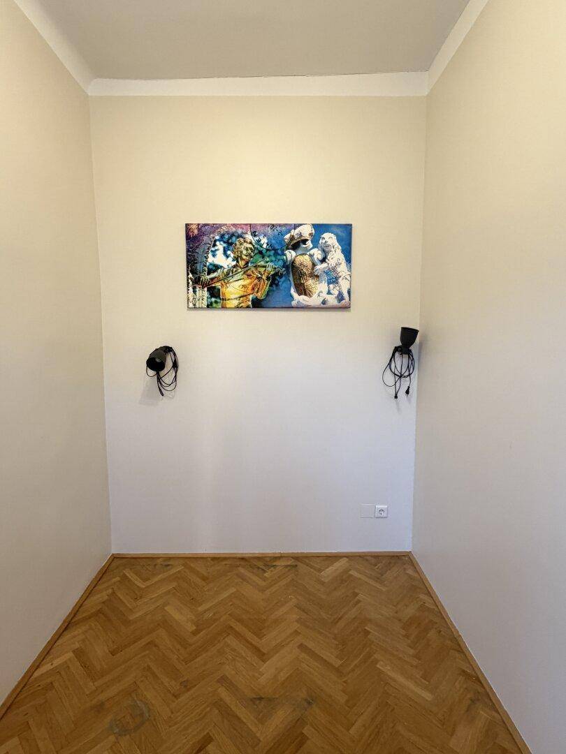 Leerer Raum mit Fischgrätparkett und Kunst an der Wand, bereit zur individuellen Gestaltung.