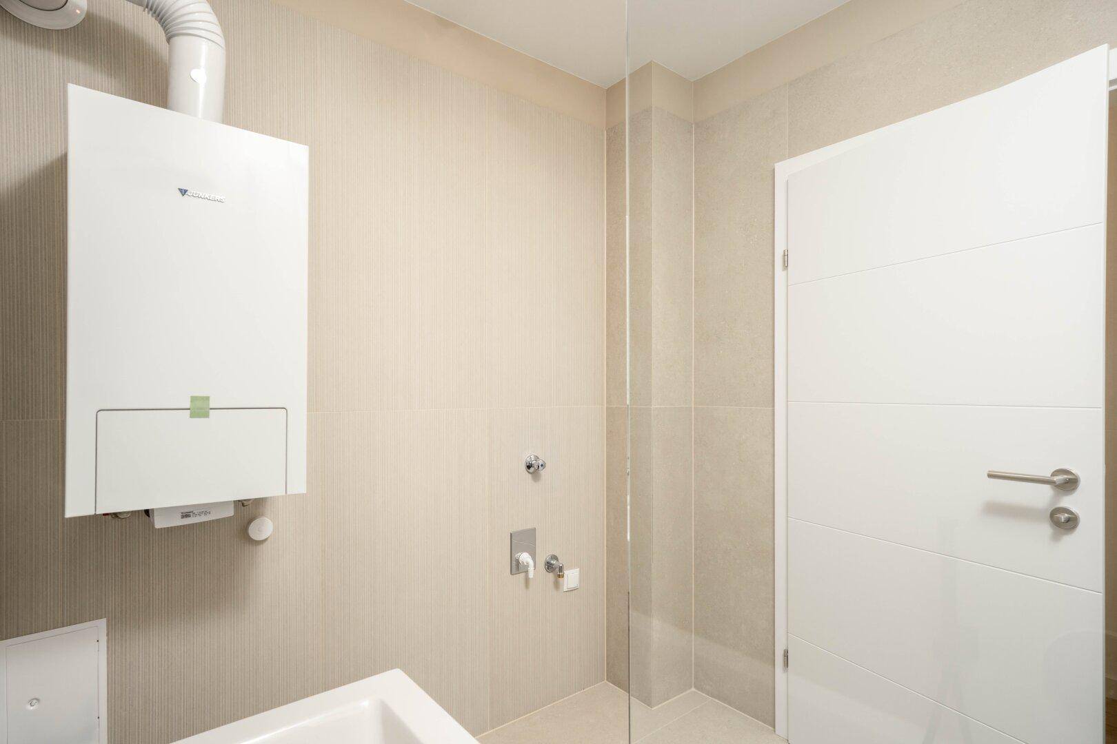 Badezimmer mit Gastherme, beigen Fliesen und moderner Ausstattung, sauber und funktional.
