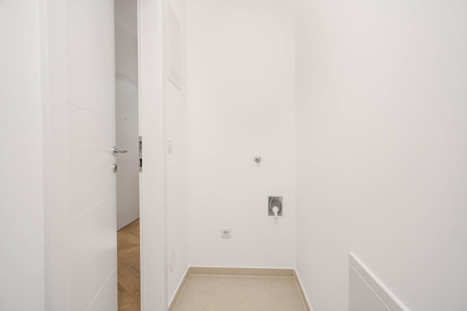 Leerer Hauswirtschaftsraum mit Anschlüssen für Waschmaschine und Trockner, bereit zur Nutzung.
